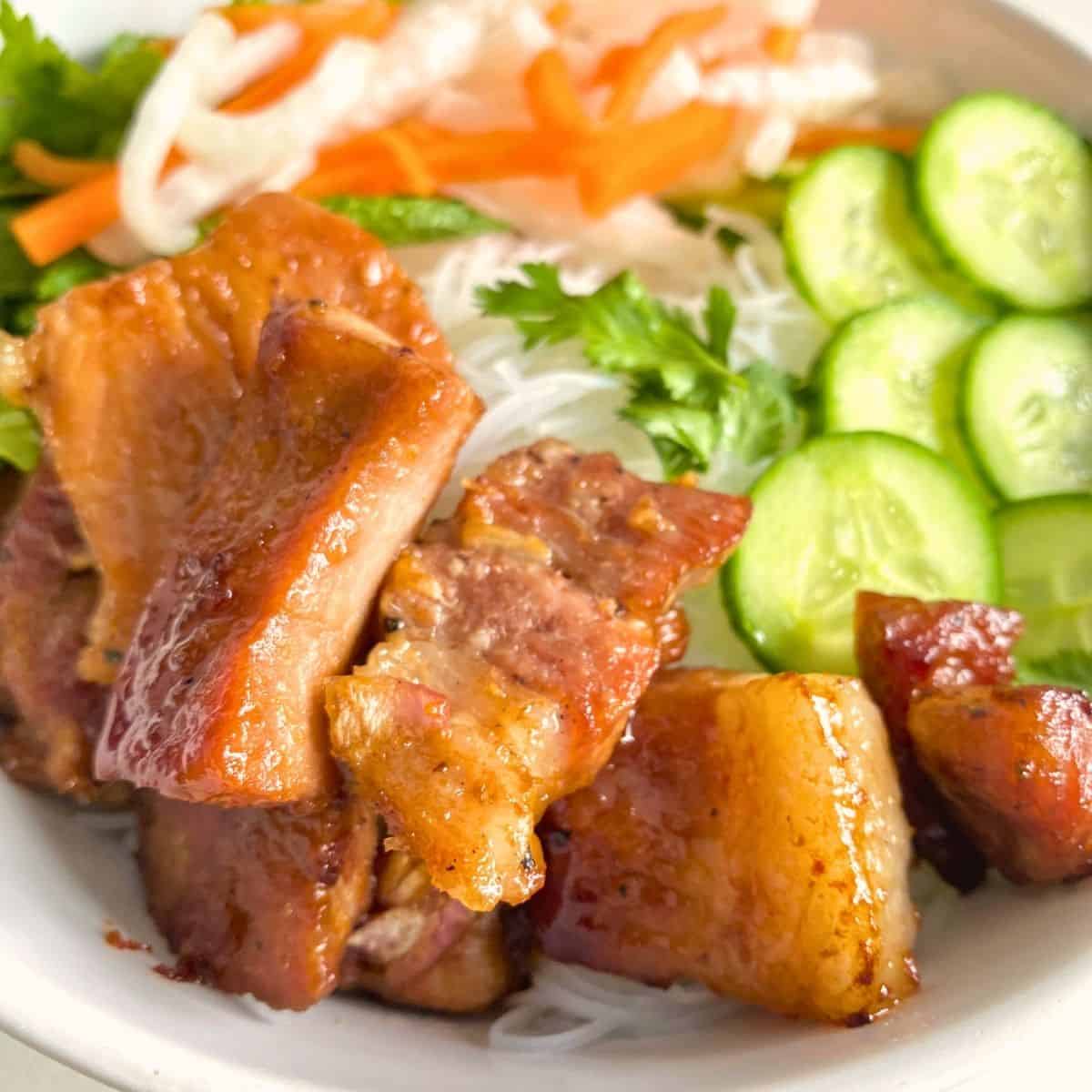 Succulent roasted pork with crispy skin, served with fresh cucumber slices, shredded carrots, and herbs in a vibrant, healthy Asian-inspired dish. Perfect for nutritious, flavorful meals.